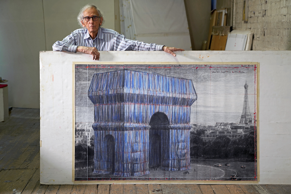 Christo in his studio with a preparatory drawing for L'Arc de Triomphe, courtesy to Fondation Linda et Guy Pieters.