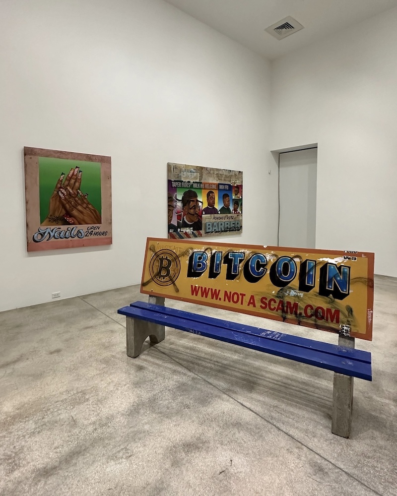 Installation view of Alfonso Gonzalez Jr.'s “Your Ad Here” (2021), in front of “24HR NAILS,” and “El Chavalon Barbería” (2023) at Rubell Museum in Miami